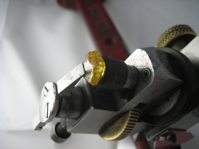 Fancy yellow rough diamond shown in a diamond cutting tool in the process of being cut